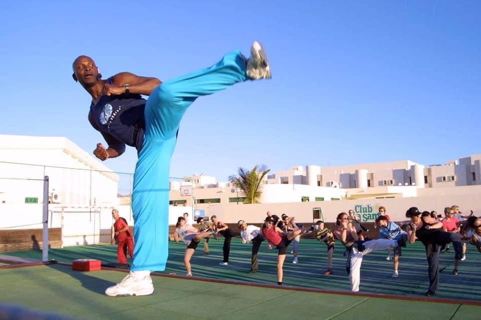 Charles leading a Kara-T-Robics class while demonstrating a controlled high kick